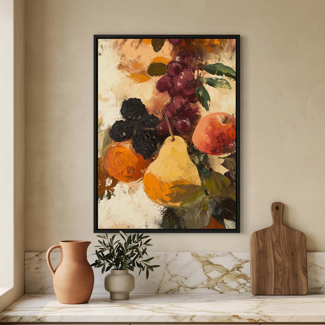A framed vertical art print depicting a still life of fruit, including a pear, grapes, and an orange, displayed on a beige wall above a marble-topped surface with a terracotta pitcher, a small potted plant, and a wooden cutting board.