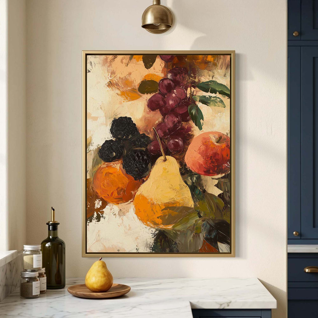 A framed still life painting of fruit, including a pear, grapes, and an apple, hanging on a cream-colored wall above a marble countertop with kitchen items.