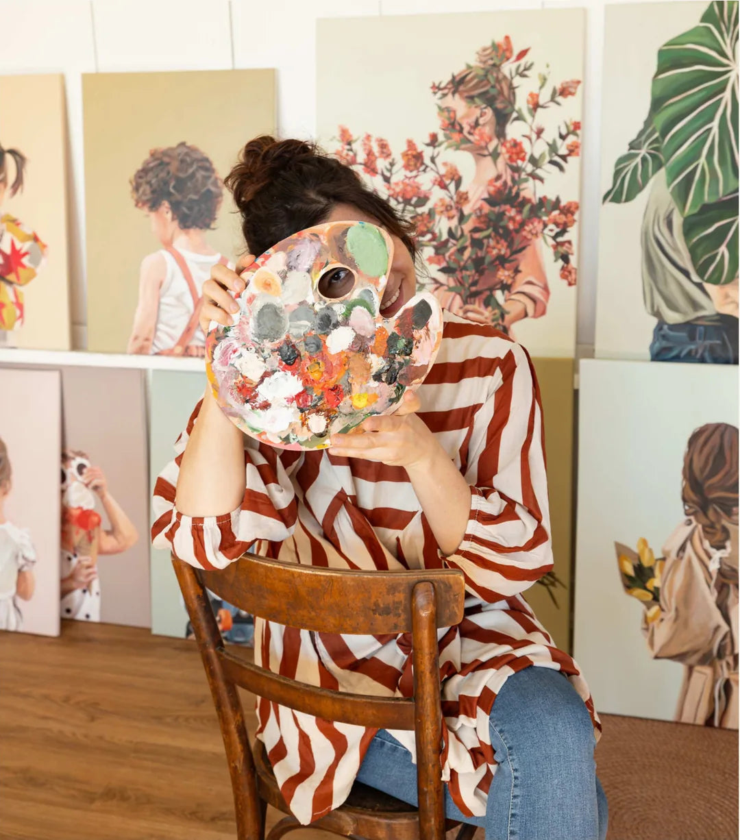 Artist Jeannine Läderach looking through her paint palette in her studio.